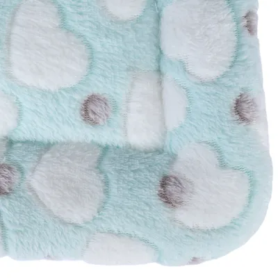 Weiche, hellblaue Stoffoberfläche mit weissen Wolken- und grauen Punktmustern. Detailaufnahme des Materials.