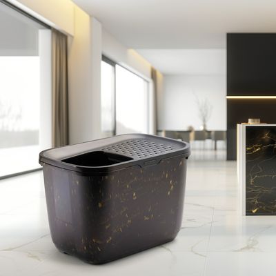 Czarna kuweta dla kota ze złotymi akcentami, zamknięta, z wbudowanym sitem do łatwego czyszczenia.