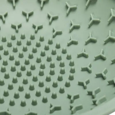 Surface intérieure en plastique vert avec picots ronds et motifs en forme de Y, vue rapprochée d’un accessoire pour animaux. Aucun texte ou marque visible.