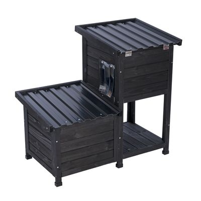 Zwart houten huis met twee verdiepingen en golfplaten dak, geschikt voor buiten. Zijdelingse metalen houder zichtbaar.