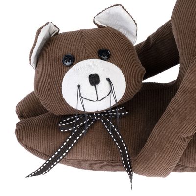 Коричневая мягкая игрушка в форме кошки с пуговичными глазами, белым лицом и в горошек бантом.