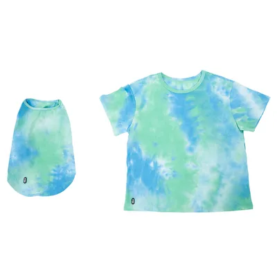 Set composto da T-shirt batik blu-verde e maglietta per cane abbinata. Entrambe con piccolo logo visibile in basso a sinistra.