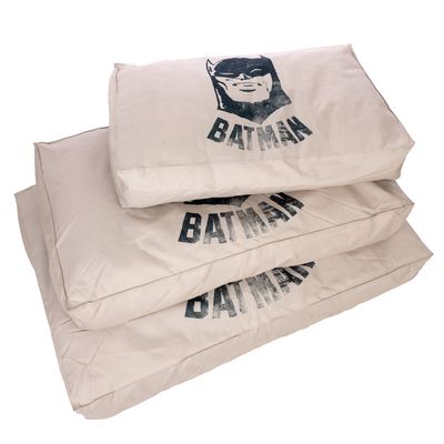 Drie beige hondenkussens met Batman-logo en het opschrift 'BATMAN' op het oppervlak.