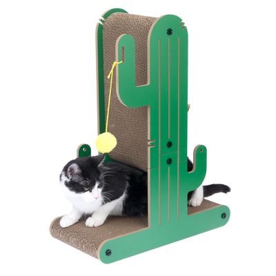 Chat noir et blanc assis sur un griffoir en carton avec structure verte en forme de cactus et balle jaune suspendue, tous éléments visibles.