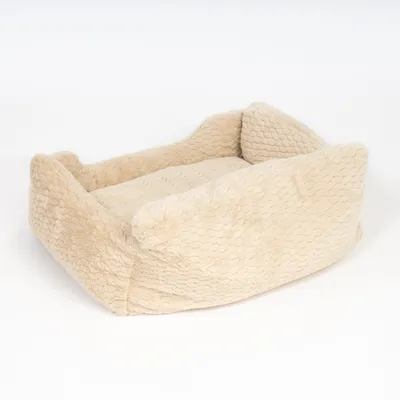 Panier pour animal en tissu beige à surface texturée, forme rectangulaire avec bords hauts et coussin intégré, sans marque visible.