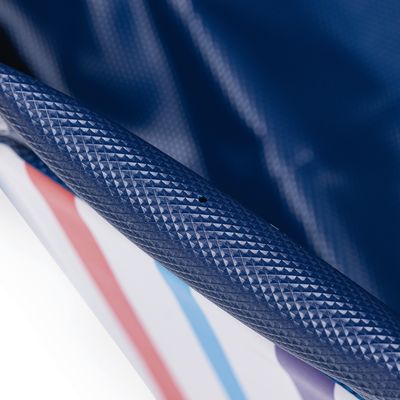 Närbild av en blå, strukturerad yta med röda och blå ränder på vit bakgrund.