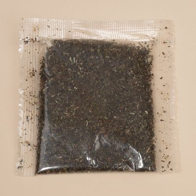 Transparent pouch with dried herbs, visibly finely chopped.
