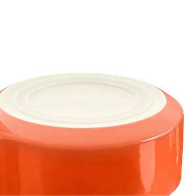 Keramiknapf in orange mit weisser Unterseite, geeignet für Haustierfutter oder Wasser.
