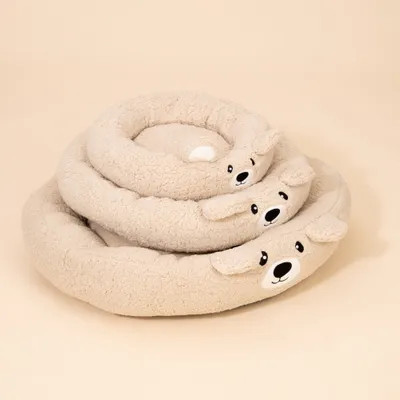 Drei runde, beige Kuschelbetten mit Bärengesicht und Ohren, übereinander gestapelt. Weiches Material sichtbar. Drei runde, beige Kuschelbetten mit Bärengesicht und Ohren, übereinander gestapelt. Weiches Material sichtbar.