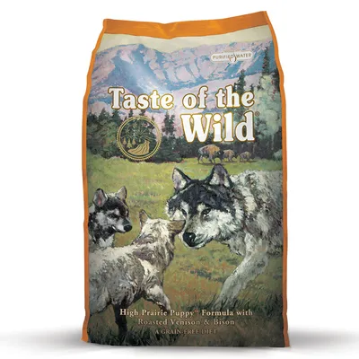 Balení krmiva Taste of the Wild. Viditelný text: High Prairie Puppy Formula with Roasted Venison & Bison, A Grain-Free Diet, Purified Water. Ilustrace vlků na louce.