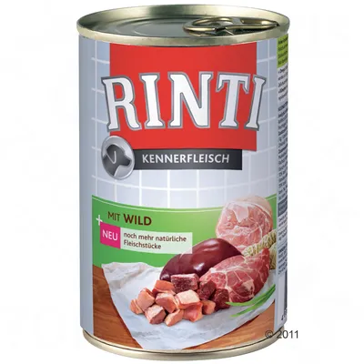 Lata de comida para perros Rinti Kennerfleisch. Texto visible: 'Mit Wild', 'neu noch mehr natürliche Fleischstücke'. Imagen de trozos de carne y órganos en la etiqueta.