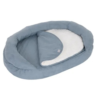 Cama para mascotas ovalada y azul con interior de felpa blanca desmontable. Adecuada para comodidad y calor.