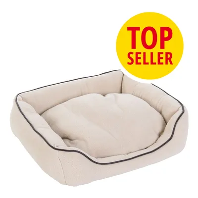 Cama rectangular beige para mascotas con borde elevado y ribete oscuro. Sello amarillo con texto en inglés: TOP SELLER.