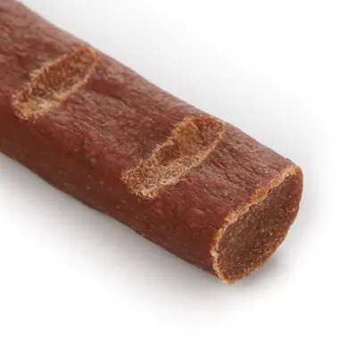 Närbild av ett brunt tuggben med mjuk textur och synliga skåror.