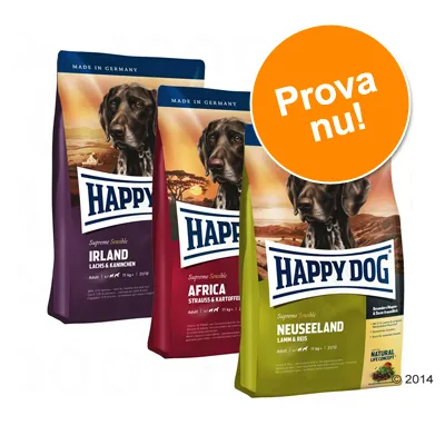 Tre påsar Happy Dog hundfoder: Irland (lax & kanin), Africa (struis & potatis), Neuseeland (lamm & ris). Stor orange cirkel med texten 'Prova nu!'.