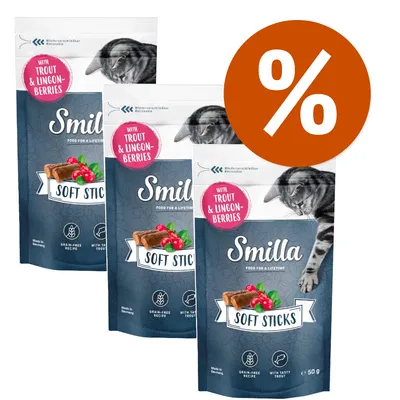 Tre confezioni di Smilla Soft Sticks con trota e mirtilli rossi, ricetta senza cereali, 50 g ciascuna. Simbolo percentuale bianco su sfondo arancione in alto a destra. Tre confezioni di Smilla Soft Sticks con trota e mirtilli rossi, ricetta senza cereali, 50 g ciascuna. Simbolo percentuale bianco su sfondo arancione in alto a destra.