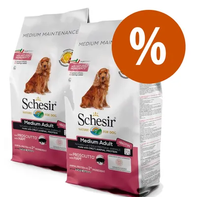 To poser Schesir Nature for Dog Medium Adult med prosciutto, synlig tekst: with natural ingredients, only animal protein, biotin. Stor procenttegn i orange cirkel.