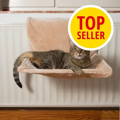 Kočka leží na béžovém pelíšku zavěšeném na radiátoru, v pravé horní části žlutý kruh s červeným textem TOP SELLER.
