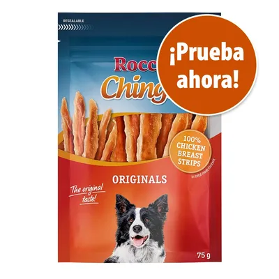 Rocco Chings Originals, tiras de pechuga de pollo 100 %, envase de 75 g. Texto visible: '¡Prueba ahora!', 'The original taste!'. Imagen de un perro en el paquete.