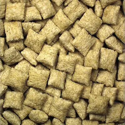 Nahaufnahme von quadratischen, beige-farbenen Trockenfutterstücken. Struktur und Form der Stücke sind deutlich sichtbar. Nahaufnahme von quadratischen, beige-farbenen Trockenfutterstücken. Struktur und Form der Stücke sind deutlich sichtbar.