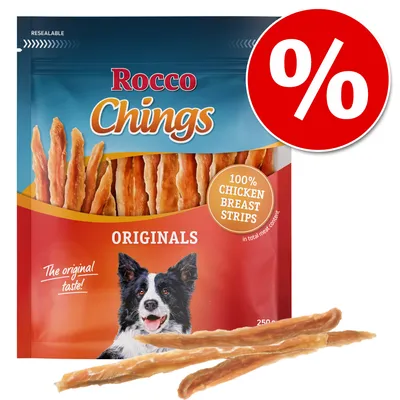 Rocco Chings Originals, 100% chicken breast strips, sachet de 250 g avec illustration de chien et symbole pourcentage rouge indiquant une offre ou promotion visible sur l’emballage.
