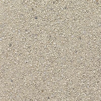 Detailní záběr na béžový, zrnitý materiál, pravděpodobně kočkolit nebo podobné podestýlkové substrát.