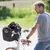 Panier de transport noir fixé au guidon d’un vélo, avec un petit chien à l’intérieur. Panier muni d’une partie supérieure en filet.