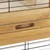 Vista dettagliata di una gabbia in legno con griglia metallica e maniglia incassata per apertura facile.