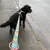 Hund i färgglatt koppel med paisleymönster och matchande sele på en trottoar.