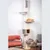 Tall scratching post with multiple levels, including a cave and grey fabric resting areas. An orange cat is lying on one of the platforms.