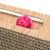 Giocattolo in legno con una sfera di plastica rosa e elementi in cartone ondulato, adatto per il gioco interattivo.