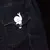 Clip blanco en forma de caracol, sujeto al bolsillo de una chaqueta vaquera oscura.