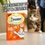 Dreamies Creamy treats with chicken, no added sugar, taurine, no artificial colours or flavours. Text: Irresistible to cats and kittens. Cat approaching product box.