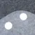 Gros plan sur une surface en feutre gris clair et foncé avec deux trous ronds visibles. Matériau textile, détails de texture et découpes circulaires.