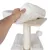 Hand showing removable white plush cushion on a wooden platform of a scratching post with sisal column and hanging play ball.