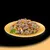 Chunks of meat with peas and diced carrots served on a yellow plate, shown as a serving suggestion for pet food.