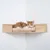 Chat roux et blanc allongé sur une étagère murale en bois avec coussin beige, fixée dans un angle de pièce. Matériaux visibles : bois, tissu.