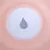 Vue rapprochée d’un objet rond en plastique rose avec un centre blanc et une ouverture en forme de goutte au milieu. Aucun texte ou marque visible.
