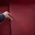 Hand öffnet eine rote Holzplatte mit eingelassenem Griff. Demonstration der Bedienung eines Möbelstücks oder einer Abdeckung.