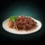 Chunks of wet pet food in gravy served on a white plate with a garnish of parsley.