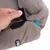 Hand opening a hook-and-loop fastener on the side of a fabric pet bed, showing how the cover can be removed for cleaning or adjustment.