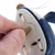 Hand inserts coin to open battery compartment of toy. Shows operation of the mechanism.
