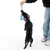 Perro juega con un juguete de cuerda azul sostenido por una persona.