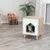 Wooden pet furniture with white front and house-shaped entrance. Small dog sitting inside on grey cushion.