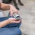 Mano sostiene una máquina eléctrica para cortar pelo de mascotas con accesorio gris, adecuada para recortes precisos.