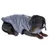 Chien de petite taille portant une veste matelassée grise, fermeture éclair visible sur le dos. Le matériau semble être du tissu synthétique.