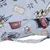 Détail d’un tissu imprimé avec motifs Harry Potter : chapeau, livre, billet Platform 9 3/4, étoiles et parchemins. Poignée en tissu assorti visible au premier plan.
