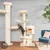 Wooden cat tree with multiple levels, resting areas and a cave. Cat climbing onto a platform. Suitable for cats to play and relax.