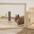 Holzgehege mit Plexiglaswänden, braunes Kaninchen im Gehege. Im Hintergrund Spielzeug aus Holz und Stoff.