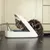 Katzenfutterautomat mit transparentem Deckel, Katze sitzt daneben und schaut hinein.